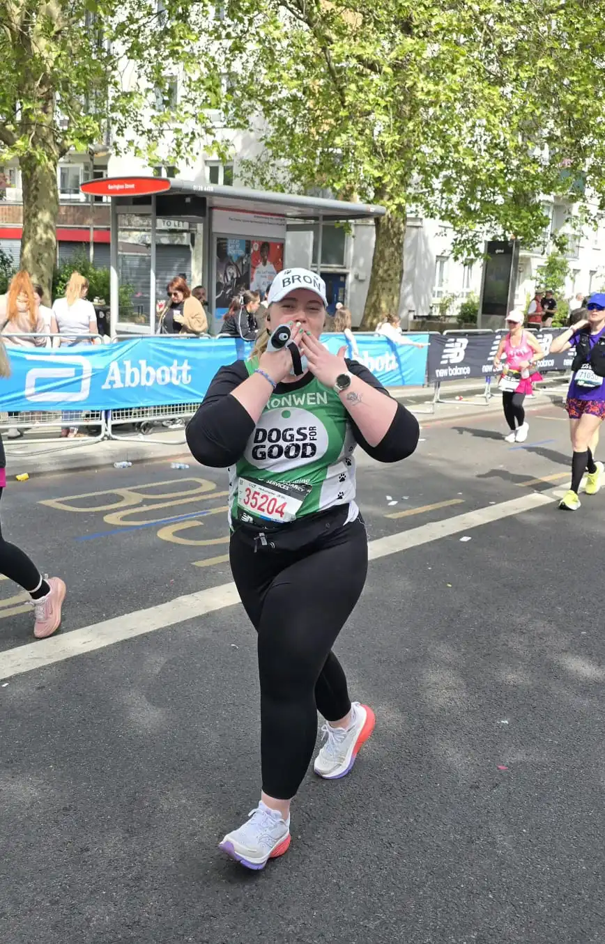 Dogs for Good fundraiser running London 2026 marathon blowing a kiss to supporters
