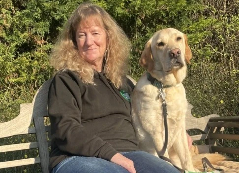 Community Dog team Sarah and Walt sitting on bench in garden