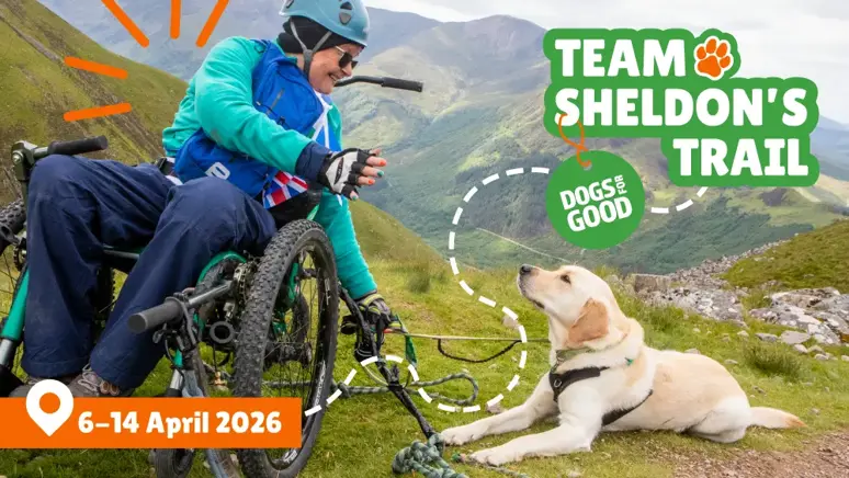 Mary and Sheldon looking at each other at the summit of a mountain with text, Team Sheldon's Trail